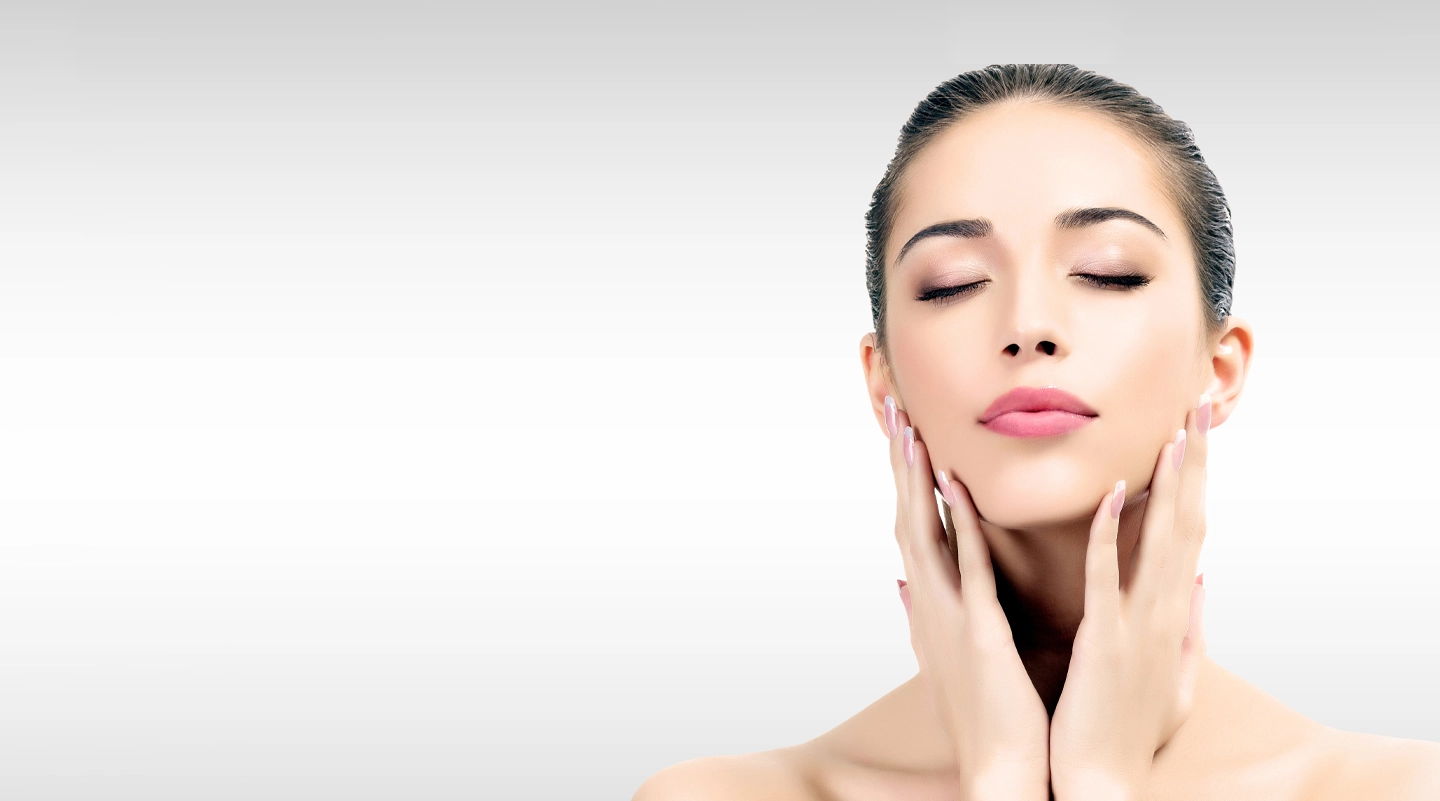pretty woman touching face against a gray background