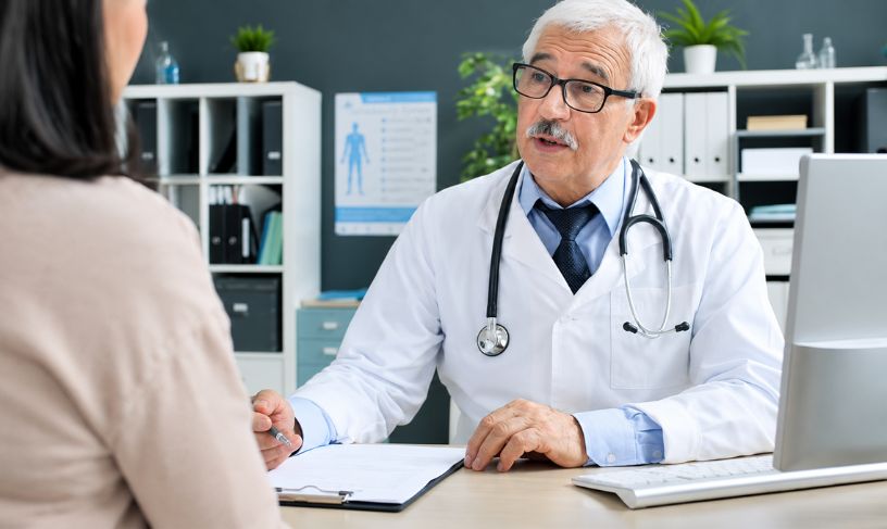 Physician reviewing medical cannabis evaluation reports with a patient during an appointment